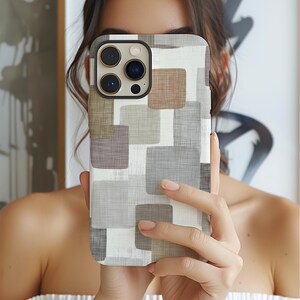 May include: A smartphone case with a geometric pattern of squares in shades of gray, brown, and white. The case has a black border around the camera lenses. The design gives a modern and artistic look to the phone.