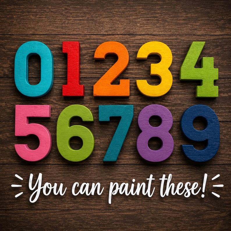 May include: A set of ten wooden numbers from zero to nine, each in a different vibrant color including teal, red, orange, yellow, lime green, pink, olive green, blue, purple, and navy. The text "You can paint these!" is printed below.