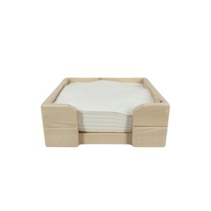 May include: A wooden napkin holder with a stack of white napkins inside. The holder is made of natural wood and has a simple, rustic design.