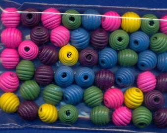 May include: A bag of colorful wooden beads with a ribbed texture. The beads are in shades of pink, yellow, blue, green, and purple.