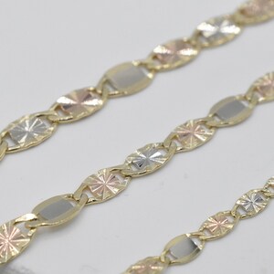 Puede incluir: Primer plano de tres cadenas de oro con una mezcla de eslabones de oro amarillo, blanco y rosa. Las cadenas presentan un patr&oacute;n repetitivo de eslabones ovalados y en forma de estrella, creando un dise&ntilde;o texturizado. Fondo blanco.