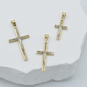 Puede incluir: Tres colgantes de crucifijo de oro y plata de diferentes tama&ntilde;os. Los colgantes presentan un dise&ntilde;o detallado de Jesucristo en la cruz.