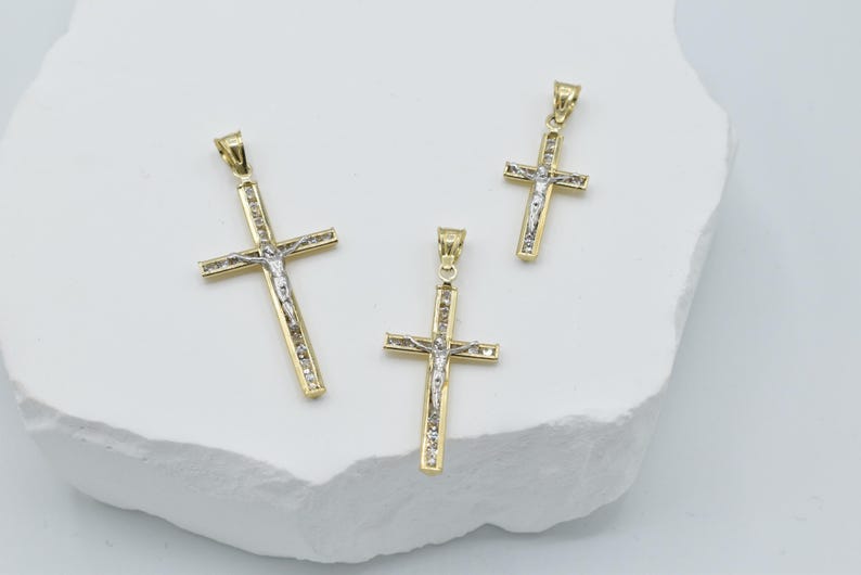 Puede incluir: Tres colgantes de crucifijo de oro y plata de diferentes tama&ntilde;os. Los colgantes presentan un dise&ntilde;o detallado de Jesucristo en la cruz.