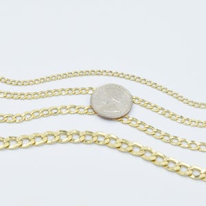 May include: Three gold chains of different thicknesses, laid out on a white surface. A US quarter is placed on top of the chains for size comparison.