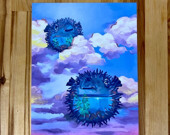 May include: A rectangular art print featuring two dark blue, spiky pufferfish floating among soft, painterly clouds in a bright blue sky. Each pufferfish contains a small, clear water-filled section with green aquatic plants inside.