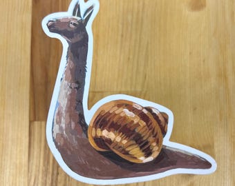 May include: A die-cut sticker featuring a hybrid creature with the long neck and head of a brown llama and the body and spiral shell of a snail. The illustration uses shades of brown, tan, and cream with a white border outline.