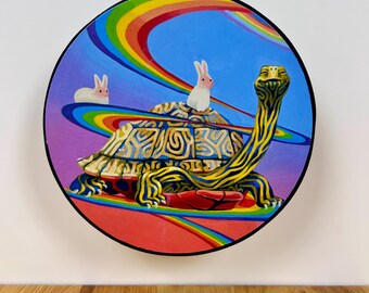 May include: A circular painting featuring a large turtle with a patterned shell and long neck, two small white rabbits sitting on its back, and vibrant rainbow arcs sweeping across a blue and purple sky background with a red ground area.
