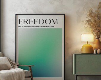 Op de afbeelding: Een zwart ingelijste poster met een groene en blauwe gradiënt achtergrond. De poster heeft het woord "FREEDOM" in grote zwarte letters bovenaan en de tekst "I AM ALLOWED TO START OVER AS MANY TIMES AS I NEED." in kleinere zwarte letters eronder. De poster hangt aan een witte muur in een kamer met een bank, een bijzettafel en een lamp.