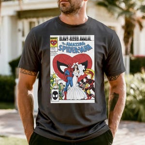 A man wearing a black t-shirt with a graphic of a comic book cover featuring Spider-Man and a bride.