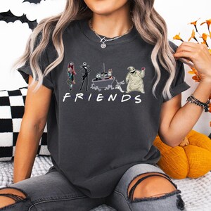 A woman wearing a black t-shirt with a graphic design of characters from the TV show Friends.