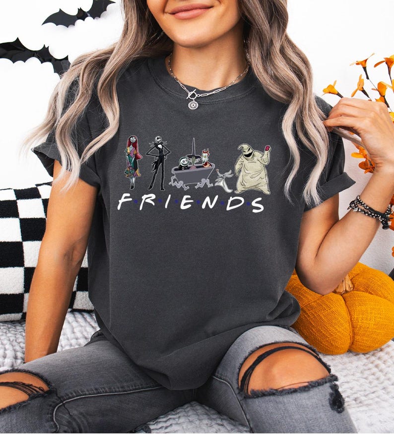A woman wearing a black t-shirt with a graphic design of characters from the TV show Friends.