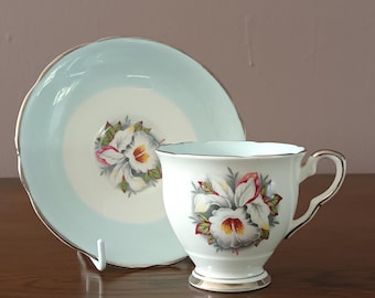Hermosa taza y platillo demitasse Royal Stafford Engkish de porcelana blanca con diseño de dama blanca, color plata lilium y orquídea, década de 1950, en excelentes condiciones.