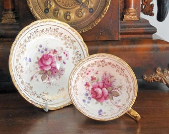 Preciosa y rara taza de té vintage Paragon Royal Ward de porcelana fina inglesa con borde ancho dorado y platillo con rosas de verano rosas, década de 1950, en excelente estado.