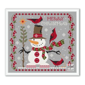 May include: A cross-stitch design featuring a snowman with a brown hat, scarf, and buttons. Red cardinals perch on the snowman and branches. The words "MERRY CHRISTMAS" are at the top, with a border of red berries and green leaves.