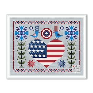 May include: Cross stitch pattern featuring a heart-shaped American flag with blue stars and red and white stripes. The flag is surrounded by bluebirds, flowers, and stars. The pattern is framed in a white frame and includes the text "iMood Stitching".
