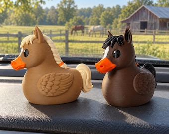 May include: Two rubber duck-shaped horse figurines. The left figurine is light brown with a cream-colored mane, tail, and wings, featuring an orange beak. The right figurine is dark brown with a black mane, tail, and wings, also with an orange beak.