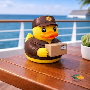 May include: A yellow rubber duck wearing a brown uniform and cap, holding a small cardboard box. The duck has an orange beak and black eyes. The background shows a wooden table, the ocean, and a blue sky.
