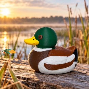 May include: A mallard duck figurine featuring a vibrant green head, a bright yellow beak, a white neck ring, and a brown body with white and black wing details. The figurine includes a small logo with the text EXCLUSIVE on the left side.
