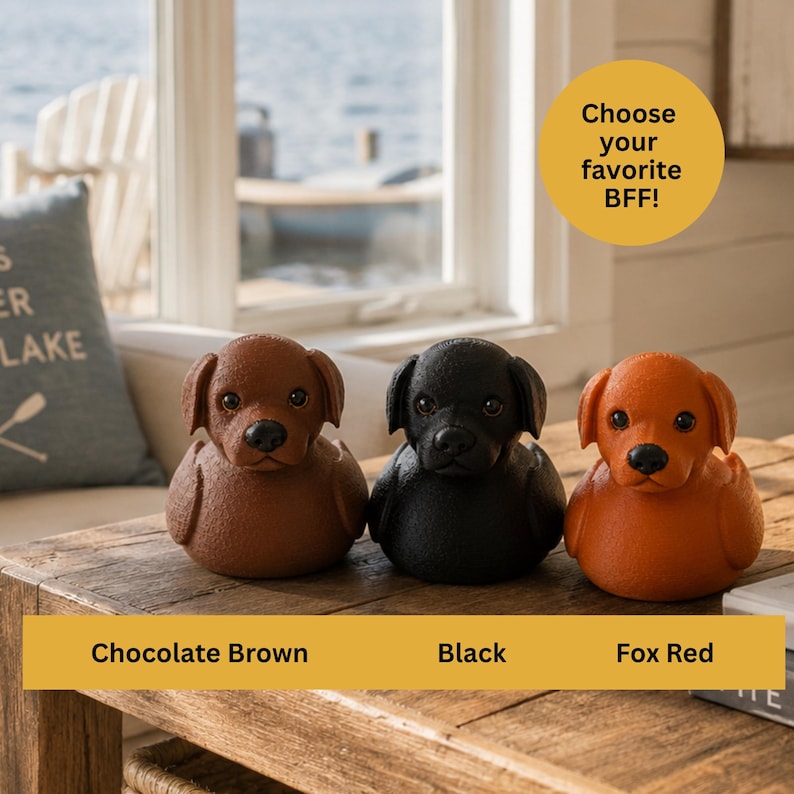 May include: Three dog-shaped figurines in chocolate brown, black, and fox red are displayed on a wooden table. The text "Choose your favorite BFF!" is in a yellow circle. Below the figurines, the text reads "Chocolate Brown", "Black", and "Fox Red".