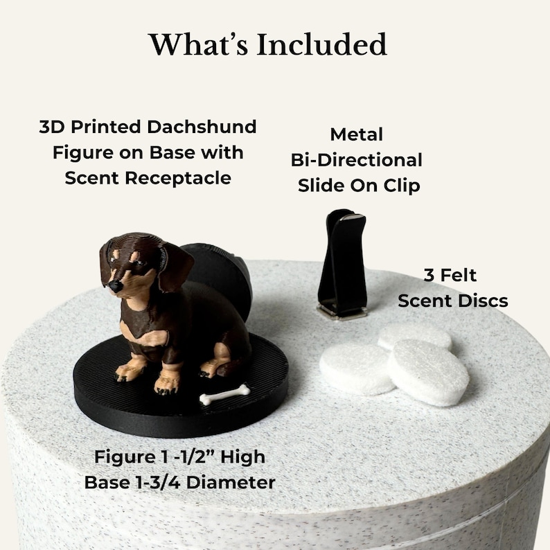 May include: A 3D printed brown and black dachshund figure on a black circular base with a scent receptacle, a metal bi-directional slide-on clip, and three white felt scent discs. The figure is 1-1/2 inches high and the base is 1-3/4 inches in diameter.