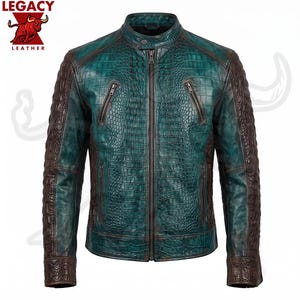 Puede incluir: Una chaqueta de color verde azulado y marrón oscuro con un patrón de textura de piel de cocodrilo. La chaqueta tiene un cuello alto con un botón a presión, un cierre de cremallera central y dos bolsillos inclinados con cremallera.