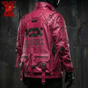 Puede incluir: Chaqueta de cuero burdeos con diseño acolchado, múltiples bolsillos y detalles en negro. La parte trasera de la chaqueta presenta el texto "HYPER ZERO" en negro. La chaqueta tiene un cuello alto y se asegura con hebillas y correas.