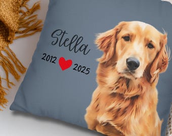 May include: A square, slate blue pillow featuring a portrait of a golden retriever. The dog's name, "Stella", is above the years "2012" and "2025" with a red heart symbol. The pillow is on a cream-colored surface.