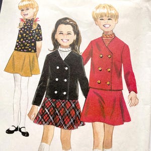 May include: Vintage illustration of three children wearing different outfits. One child is in a black floral top and mustard skirt. Another is in a black double-breasted jacket and plaid skirt. The third child is in a red double-breasted jacket and skirt.