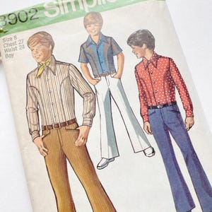 May include: Vintage sewing pattern featuring illustrations of three boys in 1970s attire. The outfits include bell-bottom pants, button-down shirts, and a patterned shirt with a neck scarf. The pattern is labeled "3902 Simplicity".