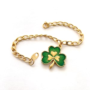 May include: Gold-tone chain bracelet featuring a green and gold shamrock charm. The shamrock has a green enamel finish with gold detailing. The bracelet is a classic accessory, perfect for St. Patrick's Day or everyday wear.