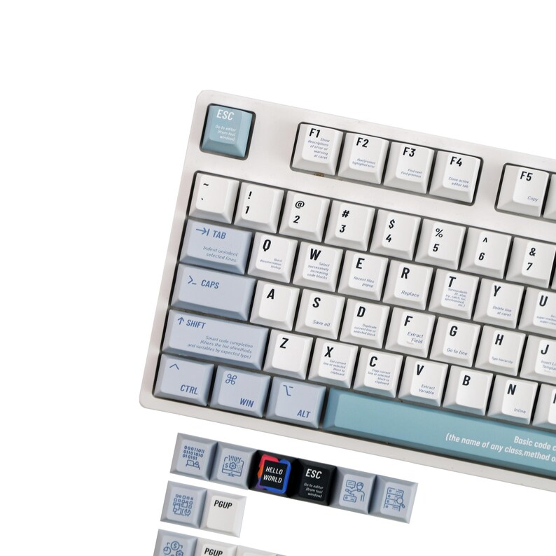 May include: A white mechanical keyboard with light blue accents. The keyboard has white keycaps with black lettering and symbols. Additional keycaps are below the keyboard with the text "HELLO WORLD" and other icons. The keyboard is designed for computer use.