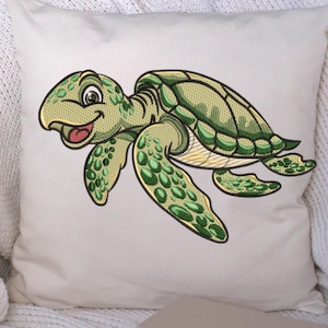 Könnte beinhalten: Weißes quadratisches Kissen mit einer Cartoon-Meeresschildkröte in Grüntönen. Die Schildkröte hat ein lächelndes Gesicht und ein detailliertes Schalenmuster. Das Kissen liegt auf einer weißen Strickdecke.