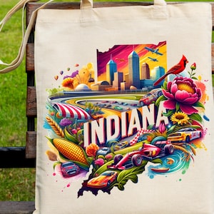 Puede incluir: Bolso tote crema con una colorida ilustración de Indiana. El diseño incluye un paisaje urbano, coches de carreras, un cardenal rojo y la palabra "INDIANA". El bolso tiene correas largas y una textura de lona natural.