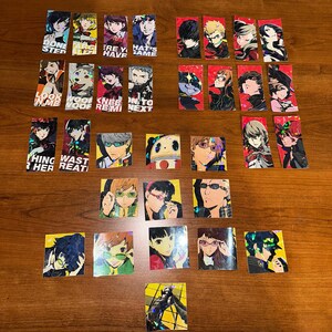 May include: A set of 20 holographic stickers featuring characters from the Persona 5 video game. The stickers are rectangular and square in shape and feature various characters from the game, including the protagonist, Joker, and his confidants. The stickers are printed on a clear background with a holographic finish.