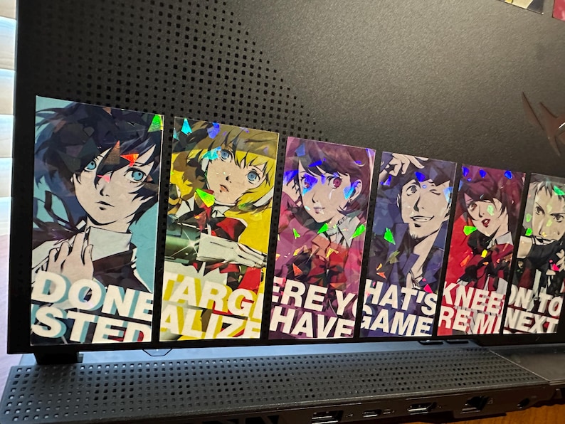 May include: Six holographic stickers featuring anime characters with text that reads "Done Stepped", "Targetalize", "Here You Have", "That's Game", "Knee Remind", and "On to Next".