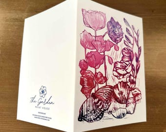 Könnte beinhalten: Gefaltete Grußkarte mit floralem Design in Rosa, Rot und Lila. Die Illustration zeigt Mohnblumen und einen Schmetterling. Die Karte trägt den Text "The Garden Print House" und ein Blumenlogo.