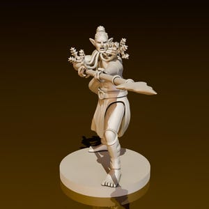 Puede incluir: Una figurita miniatura pintada de blanco de una criatura fantástica con una lanza y una corona de hojas. La criatura tiene orejas puntiagudas, una nariz larga y una expresión feroz.