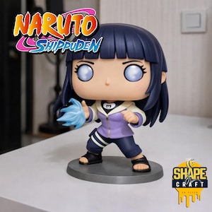 May include: A Funko Pop figure of Hinata from Naruto Shippuden. The figure has blue hair, pale skin, and is wearing a purple jacket and dark blue pants. The figure is holding a blue energy ball. The Naruto Shippuden logo is visible.