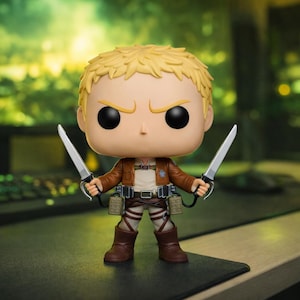 Può includere: Una statuetta Funko Pop di Reiner Braun da Attack on Titan. La statuetta ha un incarnato abbronzato, capelli biondi e indossa una giacca marrone, una camicia bianca e stivali marroni. Tiene due lame d'argento. La statuetta è su una superficie nera.
