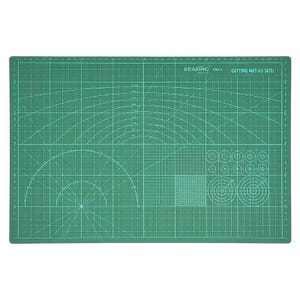 May include: Green cutting mat with grid lines, measurement markings, and various shapes. The mat has the text "KEARING CMA-3 CUTTING MAT (A3 SIZE)" printed on it. The mat is designed for crafting and cutting.
