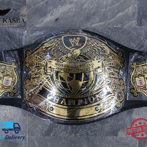 以下が含まれることがあります： 「WORLD WRESTLING ENTERTAINMENT CHAMPION」とWWEのロゴが入った、黒と金のチャンピオンベルト。 ベルトの中央には鷲と地球のデザイン、両サイドにはライオンと盾のデザインが施されています。