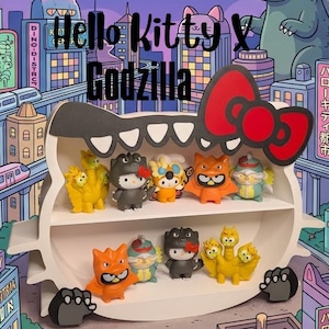 Puede incluir: Un estante de exhibición blanco con forma de cabeza de Godzilla y un lazo rojo, con dos niveles que contienen diez pequeñas figuras coloridas. El fondo es una vibrante ilustración urbana en morado y azul con el texto Hello Kitty X Godzilla.