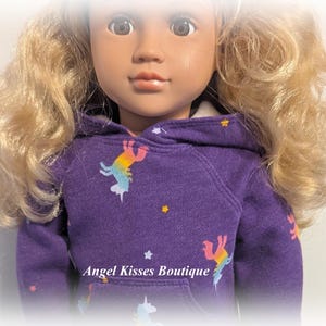 May include: A purple hooded sweatshirt with a unicorn print and stars. The sweatshirt is made of a soft, comfortable material and is perfect for everyday wear.