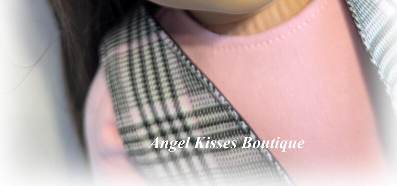 Op de afbeelding: Een close-up van een roze en witte geruite stof met een zwart-witte geruite band. De tekst "Angel Kisses Boutique" is zichtbaar in de rechterbenedenhoek van de afbeelding.