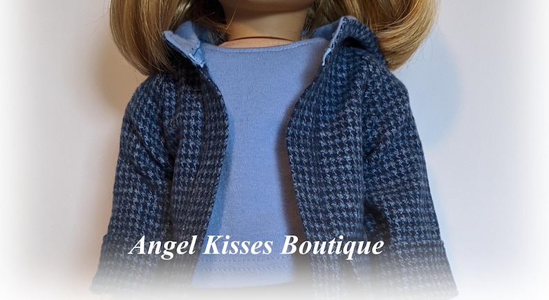 May include: A blue and grey patterned jacket with a light blue shirt underneath. The jacket has a hood and is made of a soft, comfortable fabric.  "Angel Kisses Boutique" is printed on the bottom of the image.