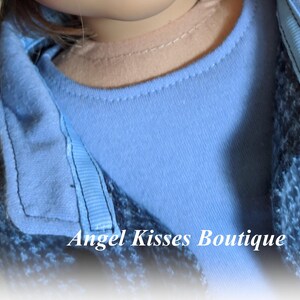 May include: A blue and white patterned jacket with a light blue collared shirt underneath. The text "Angel Kisses Boutique" is visible at the bottom of the image.