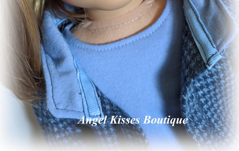 May include: A blue and white patterned jacket with a light blue collared shirt underneath. The text "Angel Kisses Boutique" is visible at the bottom of the image.