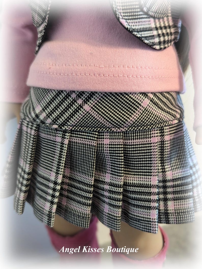 Op de afbeelding: Een zwart-wit geruite rok met roze accenten. De rok heeft plooien en is gemaakt van een zachte, comfortabele stof.