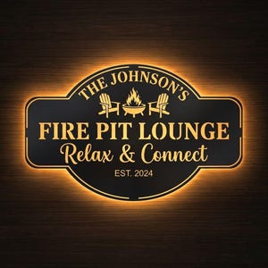 May include: A black and gold illuminated sign for a fire pit lounge. The sign reads "The Johnson's Fire Pit Lounge, Relax & Connect, Est. 2024." The design includes illustrations of chairs and a fire pit.