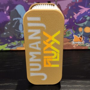 Caja de mazos Jumanji Fluxx: 120 cartas sin funda, tapa deslizante impresa en 3D y soporte para cartas de la jungla.